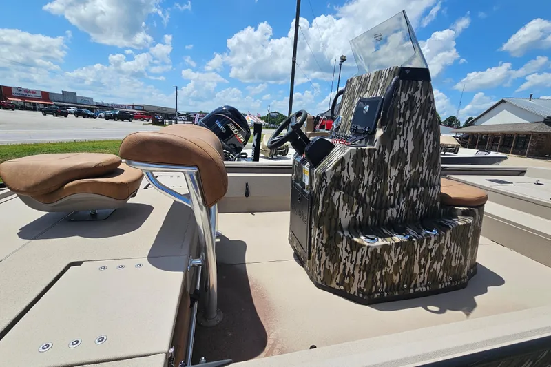 Slide: The Image of 2024 Avid 20 Rogue CC boat with camo console and tan seating under blue sky. - 4