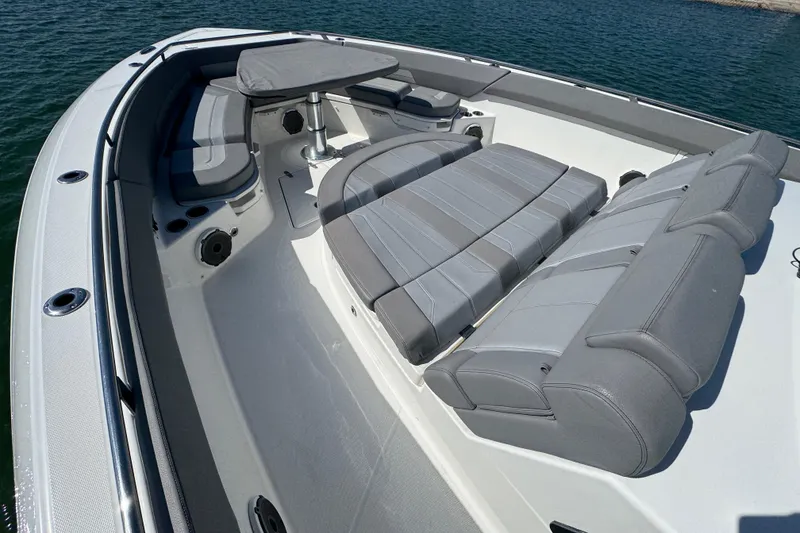 Slide: The Image of 2021 Boston Whaler 420 Outrage boat interior with luxurious seating and table on water. - 10
