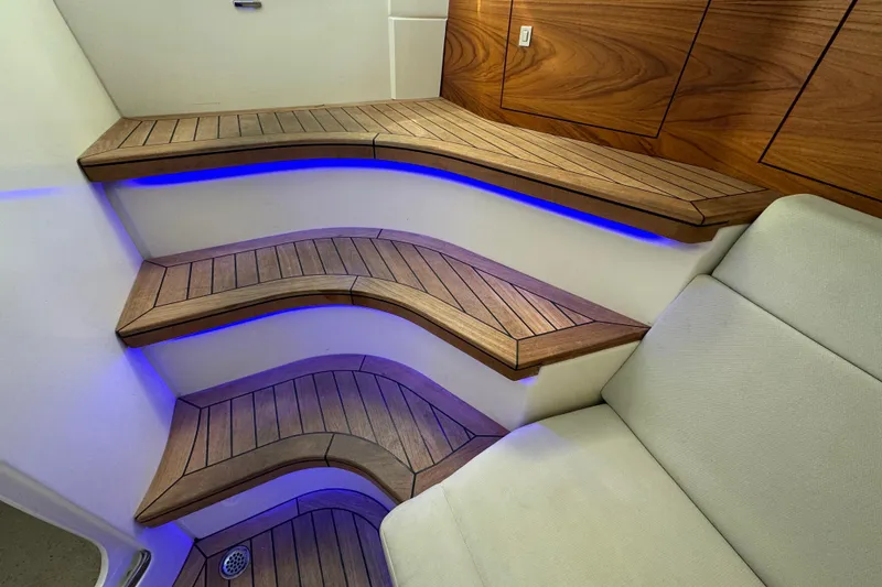 Slide: The Image of Luxurious wooden steps with blue LED lighting on a 2021 Boston Whaler 420 Outrage. - 17