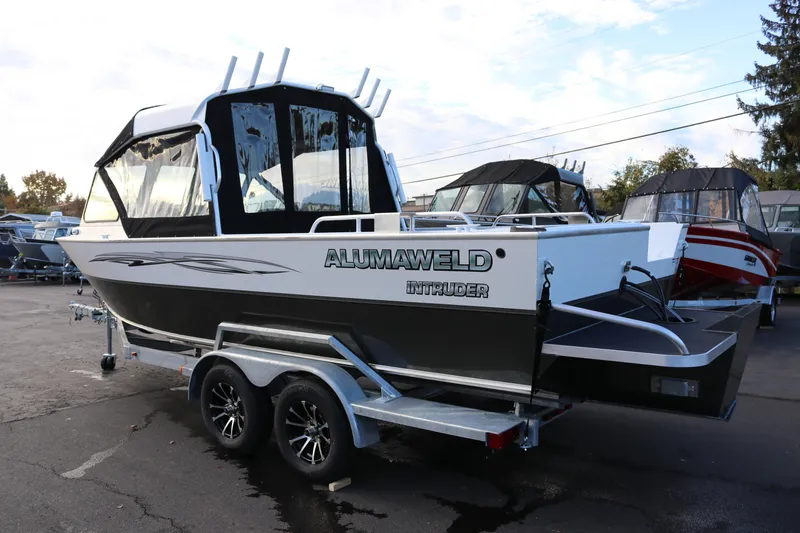Slide: The Image of 2026 Alumaweld Intruder Outboard 22 boat on trailer in parking lot. - 2