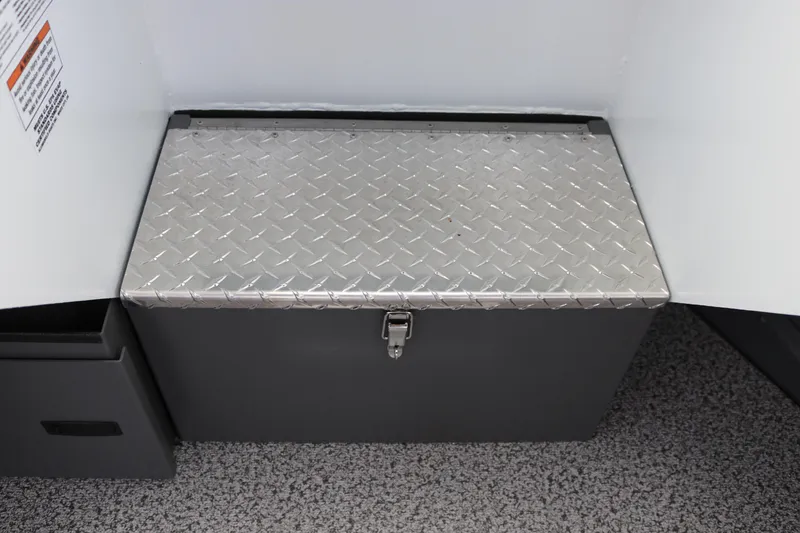 Slide: The Image of 2026 Alumaweld Intruder Outboard 22 storage compartment with open door on speckled flooring. - 22