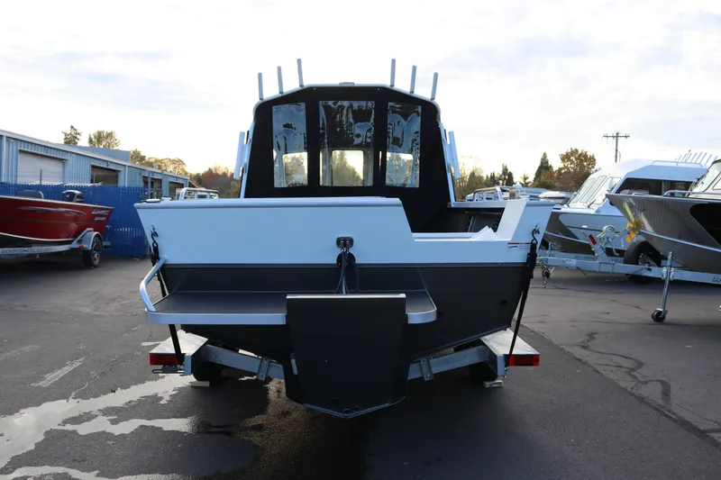 Slide: The Image of 2026 Alumaweld Intruder Outboard 22 boat on trailer, parked outside a garage. - 3