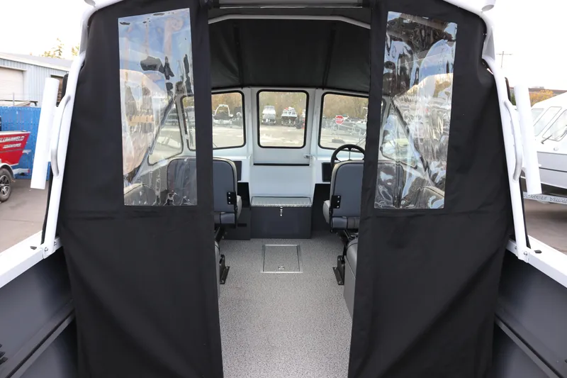 Slide: The Image of Interior view of 2026 Alumaweld Intruder Outboard 22 boat, featuring seating and windows. - 16