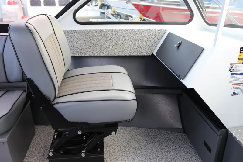 Slide: The Image of 2026 Alumaweld Intruder Outboard 22 interior with cushioned seating and storage compartment. - 8