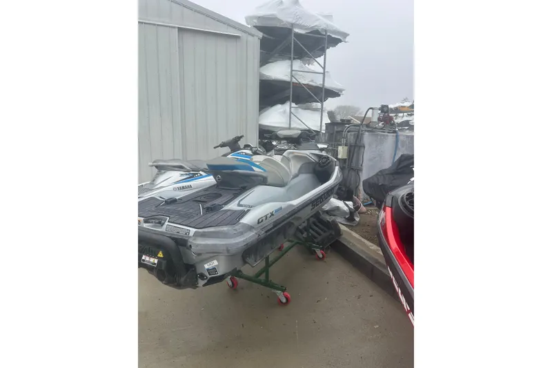 Slide: The Image of 2021 Sea-Doo GTX Limited 300 jet ski parked outdoors near storage racks. - 4