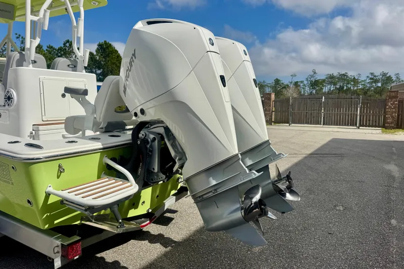 Slide: The Image of 2023 ZCB Freemason 26 boat with dual Mercury outboard engines, parked outdoors. - 4