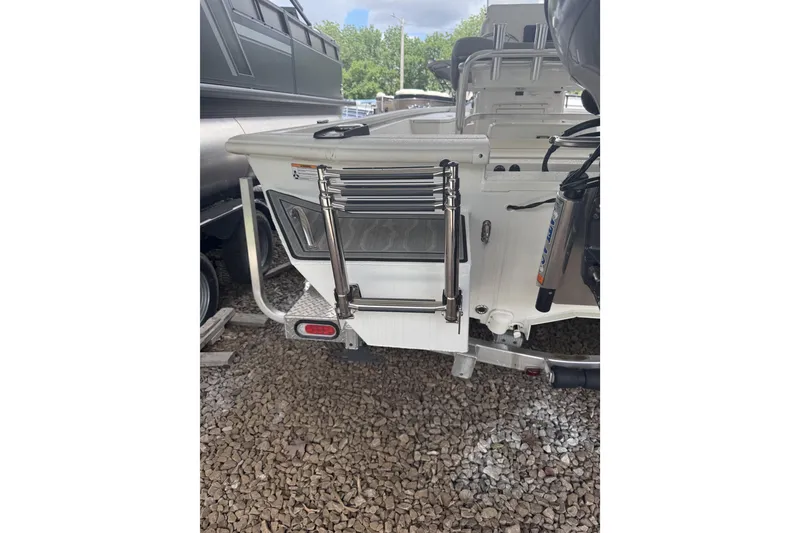 Slide: The Image of 2024 Avid 21 FST boat rear view with ladder on gravel surface. - 3