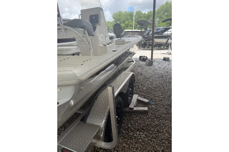 Slide: The Image of 2024 Avid 21 FST boat on trailer, parked outdoors on gravel. - 8