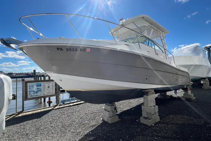 Slide: The Image of 2007 Robalo R305 Walkaround boat on blocks, sunny day, marina background. - 1