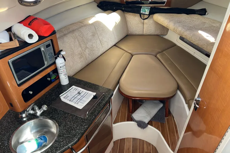 Slide: The Image of 2007 Robalo R305 Walkaround cabin interior with kitchenette, seating, and wood flooring. - 12