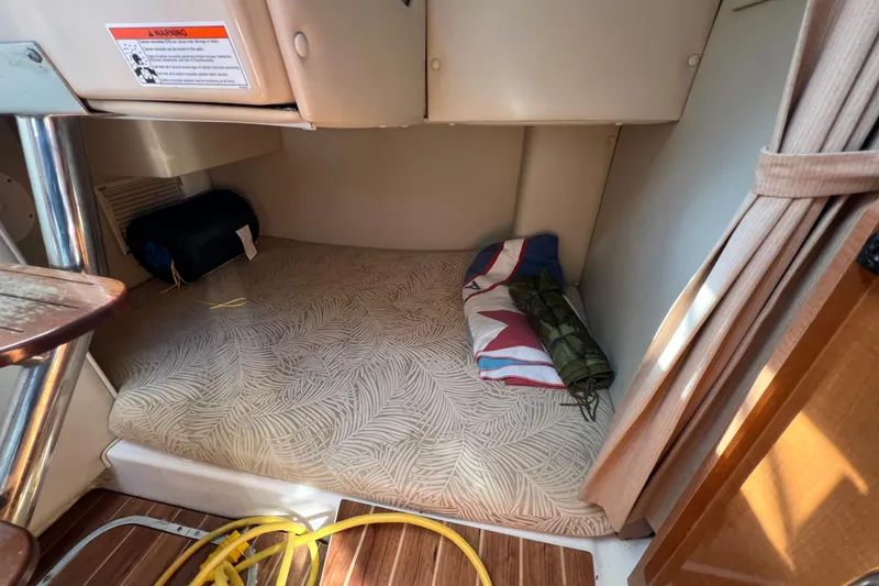 Slide: The Image of 2007 Robalo R305 Walkaround cabin interior with bedding and storage space. - 15