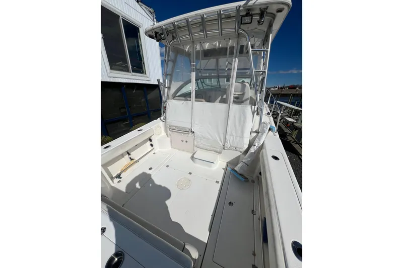 Slide: The Image of 2007 Robalo R305 Walkaround boat deck with seating and canopy under clear blue sky. - 5