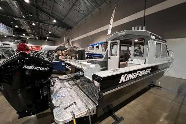 The Image of 2025 KingFisher 2225 Escape HT boat displayed indoors with Mercury engine. - 4