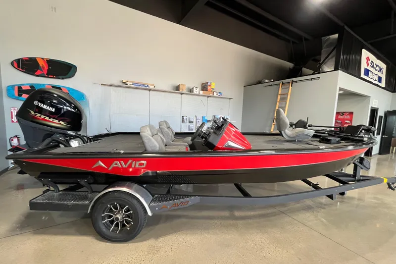 The Image of 2024 Avid 19 XB boat with Yamaha engine in showroom, featuring sleek red and black design. - 0