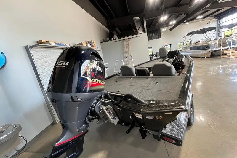 Slide: The Image of 2024 Avid 19 XB boat with Yamaha 150 engine in showroom. - 2