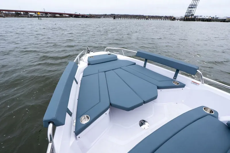 Slide: The Image of 2026 Axopar 29 XC Cross Cabin boat with blue seating on open water. - 11