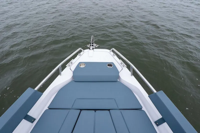 Slide: The Image of 2026 Axopar 29 XC Cross Cabin boat bow with blue seating on open water. - 12