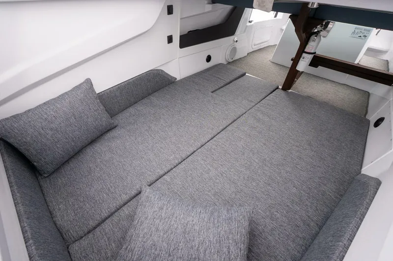 Slide: The Image of 2026 Axopar 29 XC Cross Cabin interior with gray cushioned seating and pillows. - 29