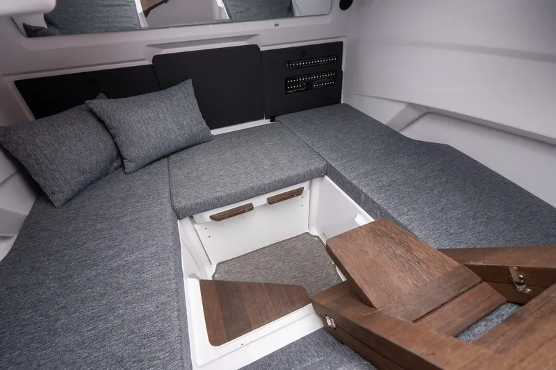 Slide: The Image of Interior of 2026 Axopar 29 XC Cross Cabin with gray cushions and wooden accents. - 30