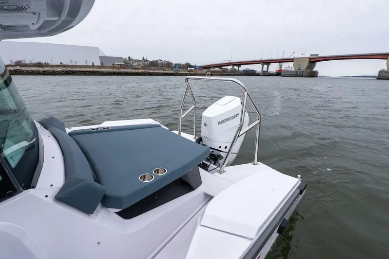 Slide: The Image of 2026 Axopar 29 XC Cross Cabin boat with Mercury engine near a bridge. - 5