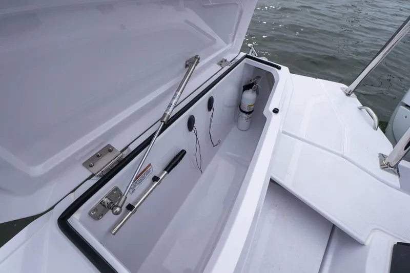 Slide: The Image of Storage compartment on 2026 Axopar 29 XC Cross Cabin boat, open with safety equipment. - 8