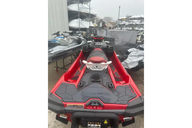 Slide: The Image of 2024 Sea-Doo RXT-X 325 jet ski, red and black, parked outdoors. - 4