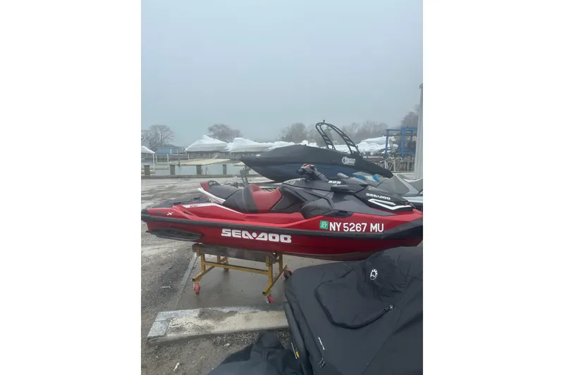 Slide: The Image of 2024 Sea-Doo RXT-X 325 jet ski in red, parked near a marina. - 9