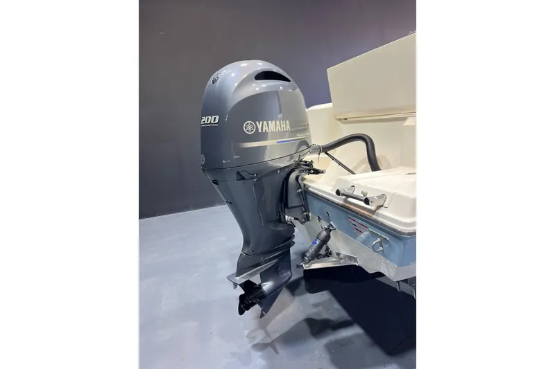 Slide: The Image of 2023 Cobia 220 Dual Console with Yamaha 200 outboard motor, showcased indoors. - 17