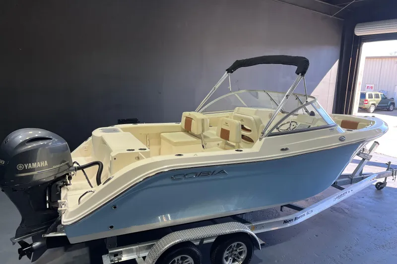 Slide: The Image of 2023 Cobia 220 Dual Console boat with Yamaha engine on trailer in garage. - 4