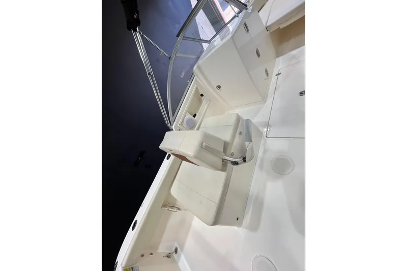 Slide: The Image of 2023 Cobia 220 Dual Console boat interior with white seating and console. - 8