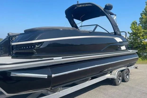 The Image of 2023 Veranda V One 25 pontoon boat on trailer, sleek black design. - 0