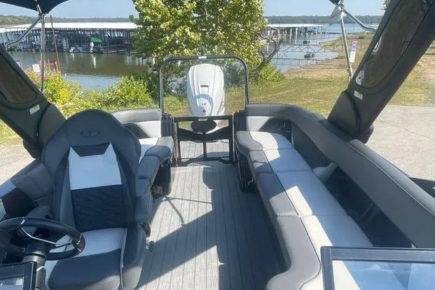 Slide: The Image of 2023 Veranda V One 25 boat interior with seating, steering wheel, and lake view. - 5