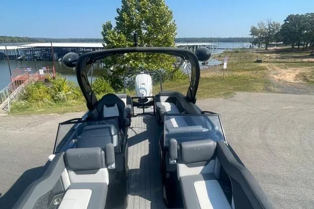 Slide: The Image of 2023 Veranda V One 25 boat with sleek seating, docked near a scenic waterfront. - 7