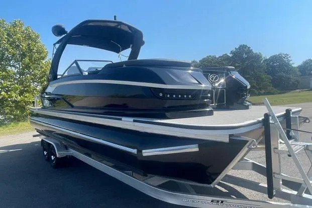 Slide: The Image of 2023 Veranda V One 25 pontoon boat on trailer, sleek black design, sunny day. - 9