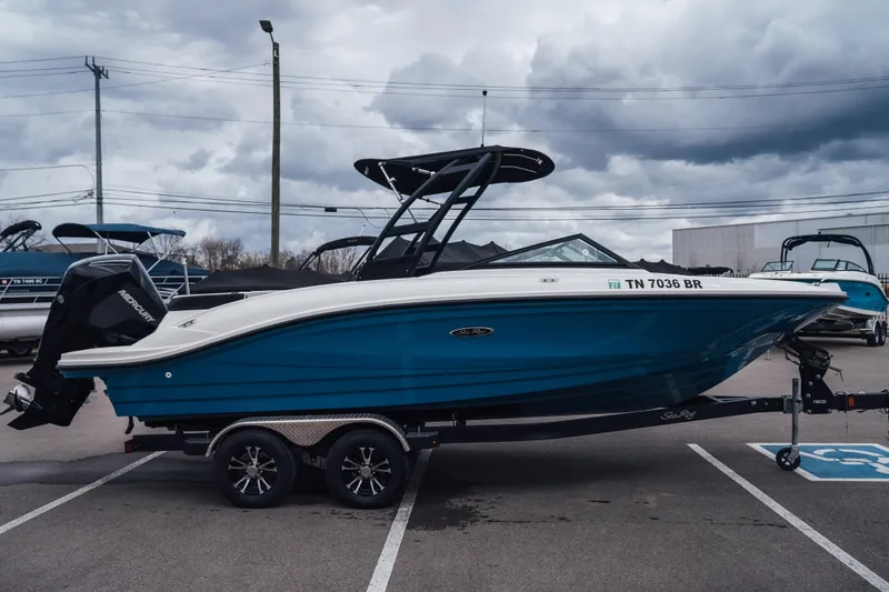 Slide: The Image of 2024 Sea Ray SPX 210 Outboard boat on trailer, parked outdoors under cloudy sky. - 1