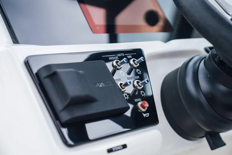 Slide: The Image of 2024 Sea Ray SPX 210 Outboard dashboard with control switches and steering wheel. - 12