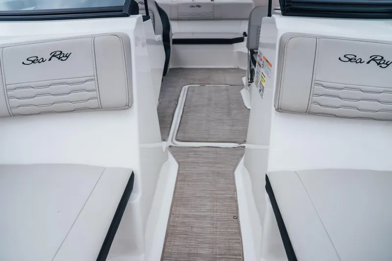 Slide: The Image of 2024 Sea Ray SPX 210 Outboard interior with white seating and logo detailing. - 19