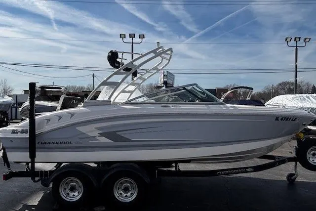 Slide: The Image of 2023 Chaparral 21 SSi boat on trailer, parked outdoors under a clear sky. - 19
