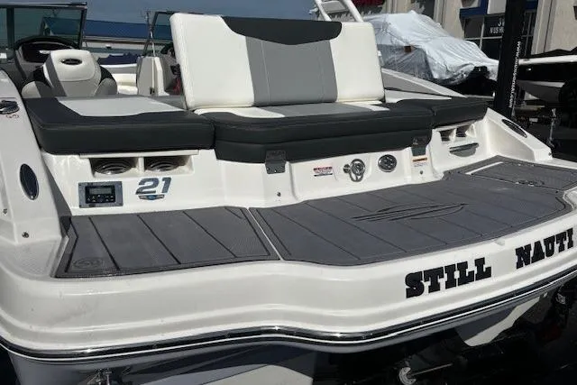 Slide: The Image of 2023 Chaparral 21 SSi boat with sleek seating and "Still Nauti" name on the stern. - 28