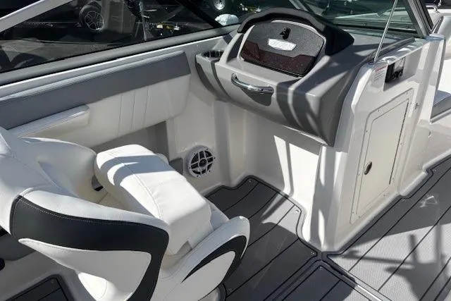 Slide: The Image of 2023 Chaparral 21 SSi boat interior with white seating and modern dashboard design. - 32