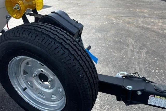 Slide: The Image of Trailer wheel of 2023 Chaparral 21 SSi boat on asphalt surface. - 35