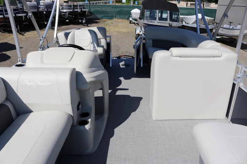 Slide: The Image of 2025 SunChaser Vista 18 LR pontoon boat interior with plush seating and steering console. - 21