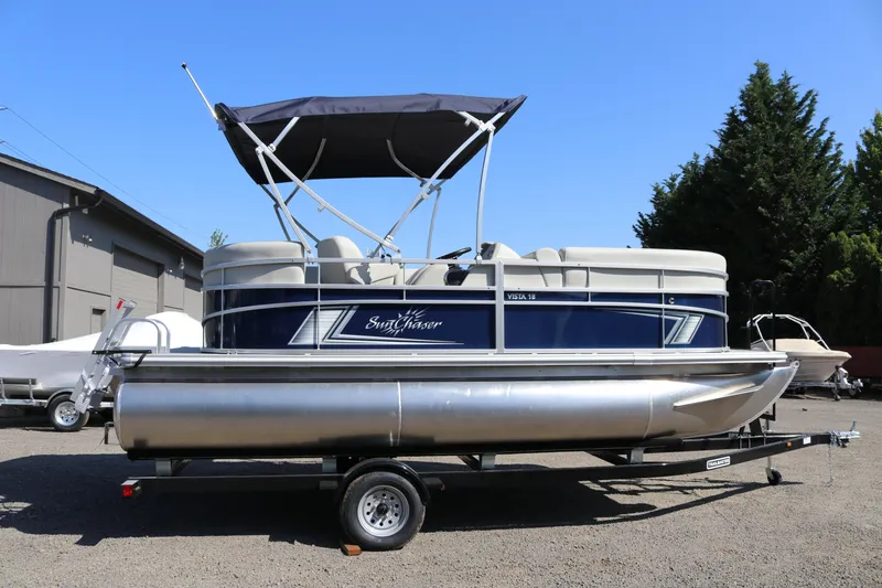 Slide: The Image of 2025 SunChaser Vista 18 LR pontoon boat on trailer, parked outdoors. - 4