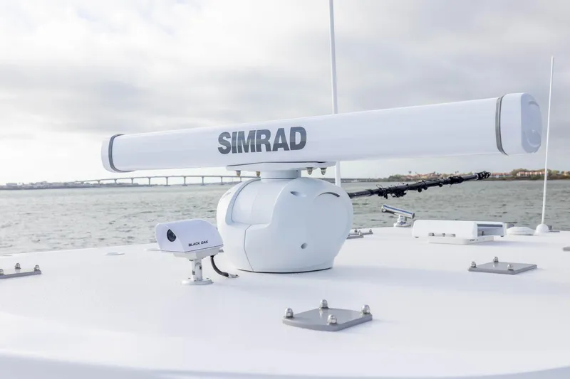 Slide: The Image of 2024 Invincible 35 Catamaran with Simrad radar system on deck, ocean backdrop. - 16