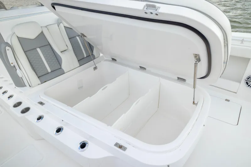 Slide: The Image of 2024 Invincible 35 Catamaran with open storage compartment and cushioned seating. - 19