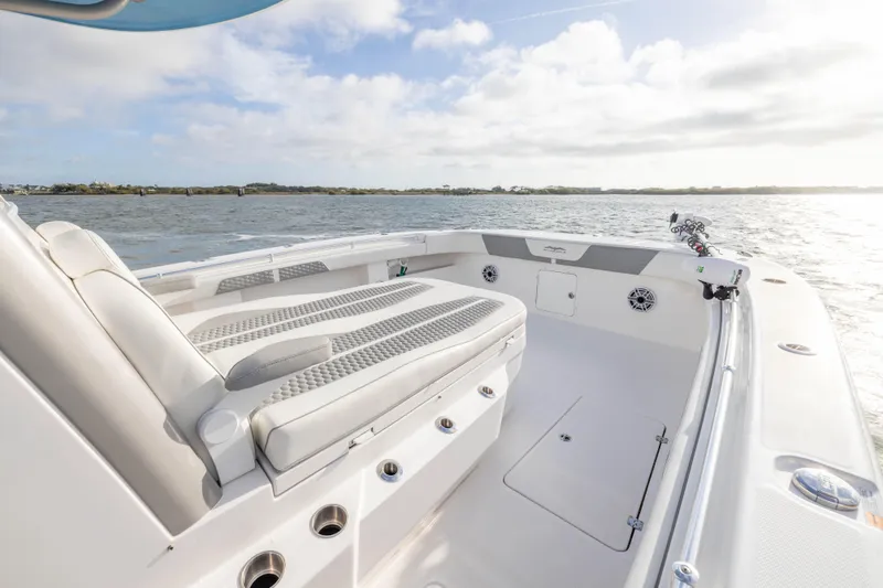 Slide: The Image of 2024 Invincible 35 Catamaran interior with cushioned seating, on a sunny day at sea. - 8