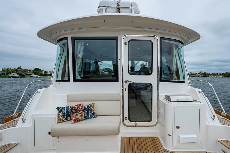 Slide: The Image of 2014 Grand Banks 46 Eastbay SX yacht with cushioned seating and scenic water view. - 11