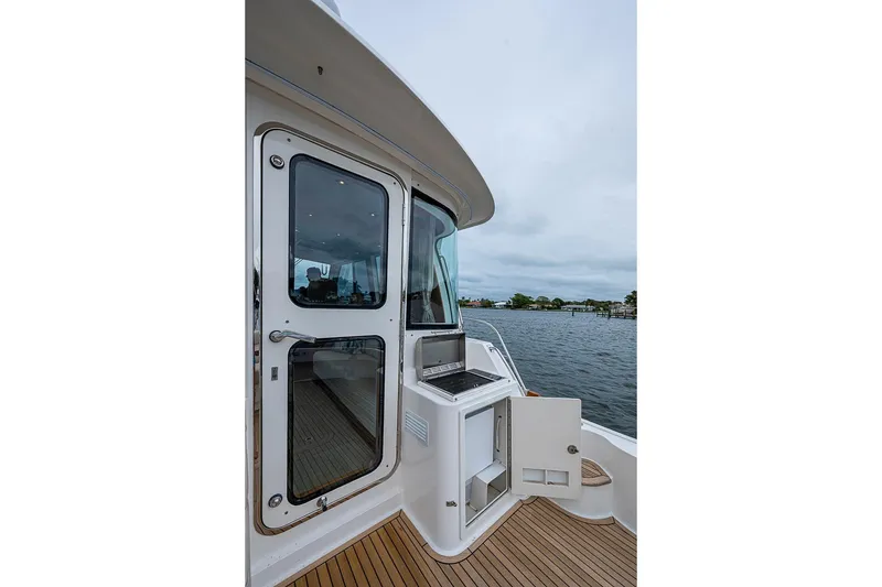 Slide: The Image of 2014 Grand Banks 46 Eastbay SX yacht deck with open storage, overlooking calm waters. - 13
