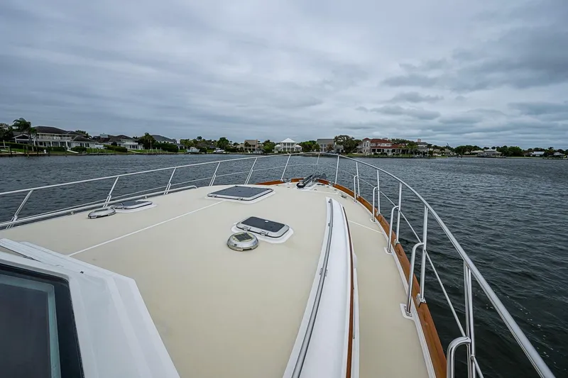 Slide: The Image of Bow view of 2014 Grand Banks 46 Eastbay SX yacht on a calm waterway. - 15