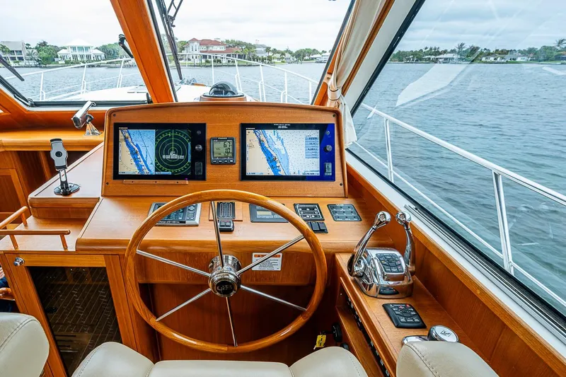 Slide: The Image of Helm of 2014 Grand Banks 46 Eastbay SX with navigation screens and wooden steering wheel. - 26